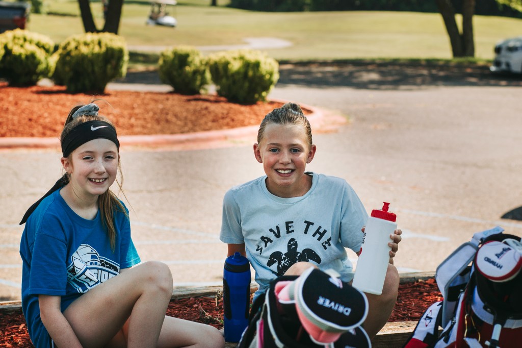 Youth golfers hanging out in front of the clubhouse